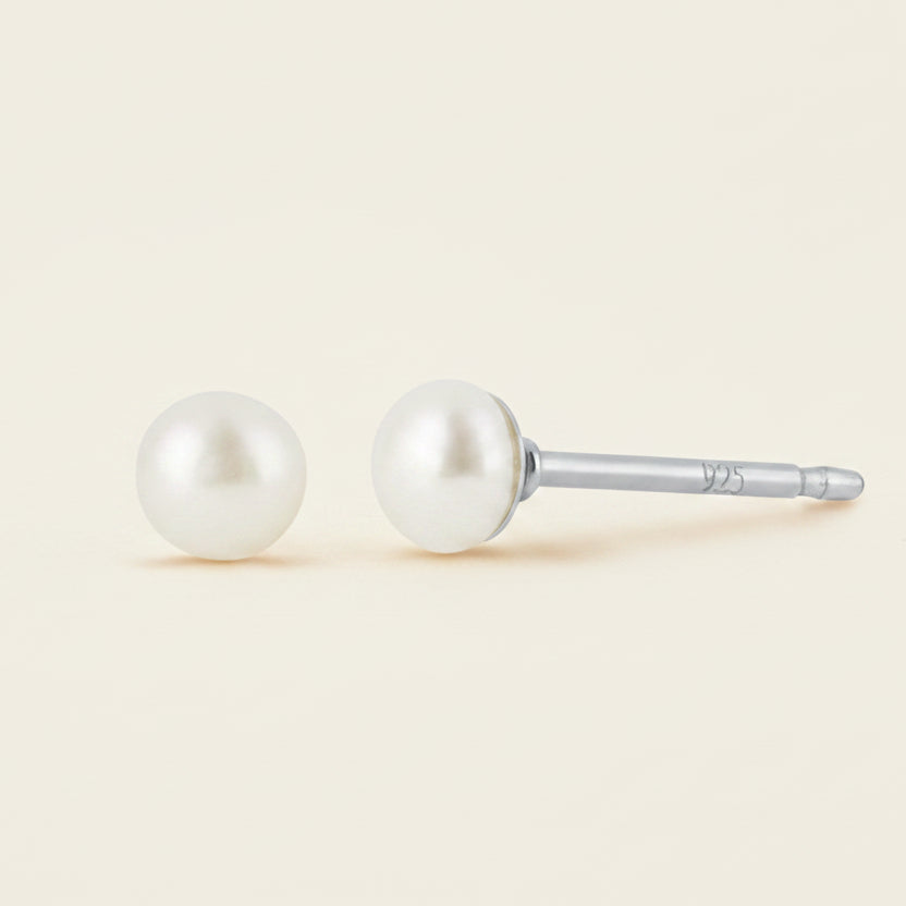 Pair of pearl stud earrings on a white background